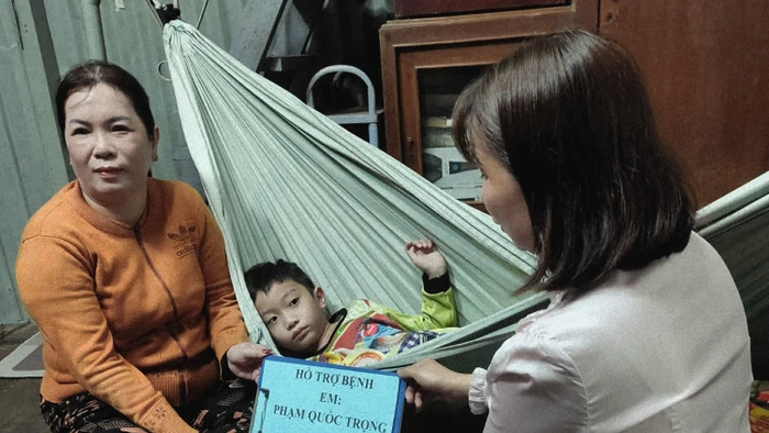 Đại diện nhà trường trao chuyển tiền các nhà hảo tâm ủng hộ bé Phạm Quốc Trọng. 