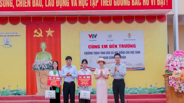 Chủ tịch Công đoàn Giáo dục Việt Nam Nguyễn Ngọc Ân cùng đại diện Quỹ Tấm lòng Việt trao học bổng cho học sinh.