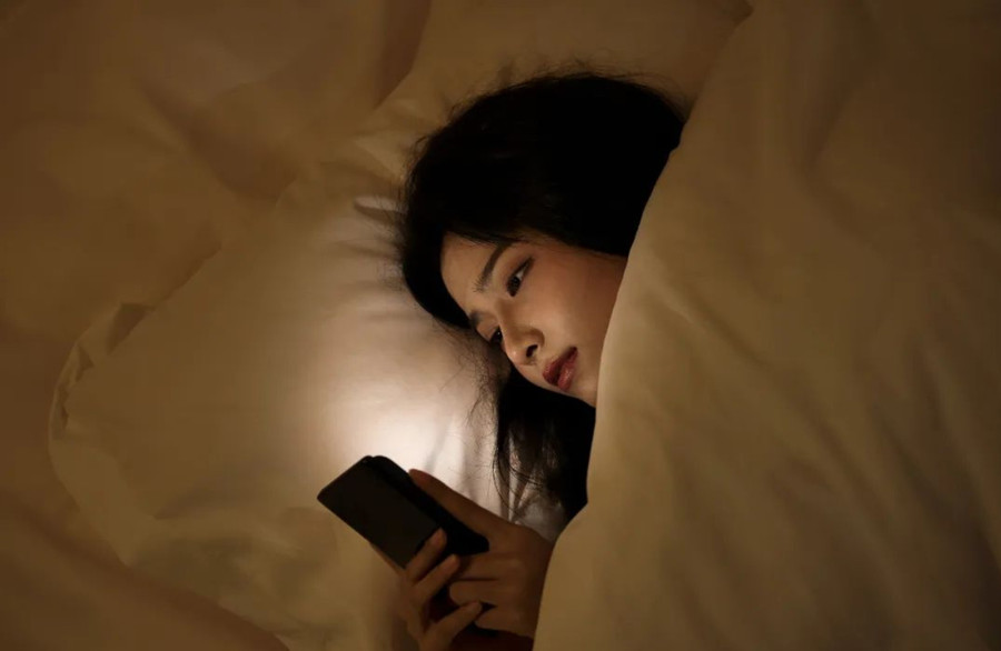 Mắt dán chặt vào màn hình điện thoại, số lần chớp mắt giảm gây ra khô mắt. (Ảnh: ITN)