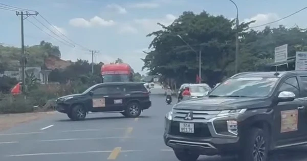 2 xe ô tô án ngữ tuyến quốc lộ, buộc các phương tiện khác phải dừng lại nhường đường.
