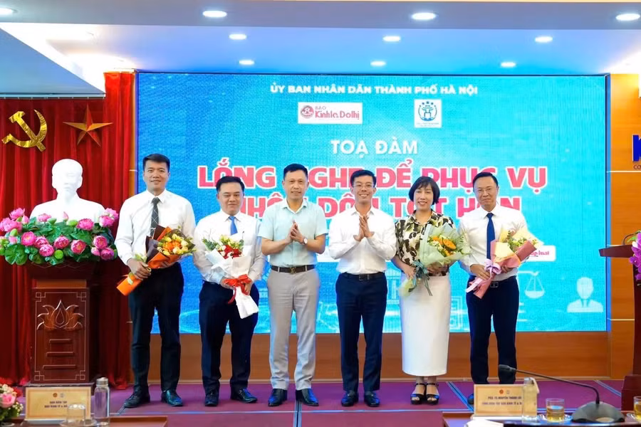 PGS.TS Nguyễn Thành Lợi - Tổng Biên tập Báo Kinh tế &amp; Đô thị và ông Cù Ngọc Trang, Giám đốc Trung tâm Phục vụ hành chính công TP Hà Nội tặng hoa các diễn giả tham gia toạ đàm