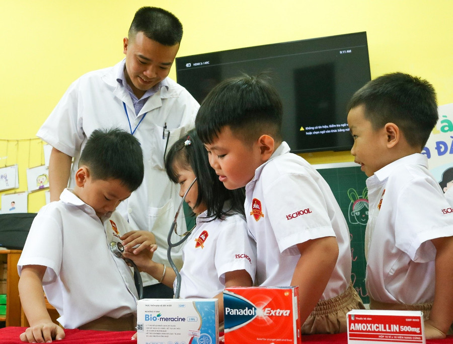 Phụ huynh lớp Kindy 5.3 đang hướng dẫn các bạn tự sử dụng ống nghe trong tiết học. image009.jpg