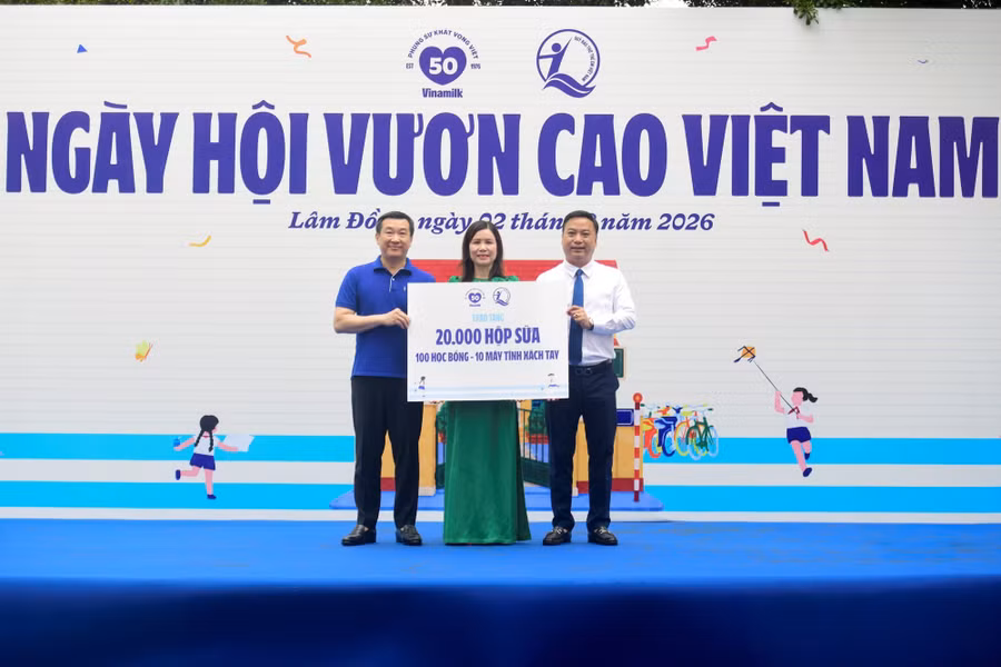 Đại diện Quỹ sữa Vươn cao Việt Nam, ông Đỗ Thanh Tuấn - Giám đốc Đối ngoại Vinamilk (bên trái) và ông Đinh Tiến Hải - Giám đốc Quỹ Bảo trợ Trẻ em Việt Nam trao bảng tượng trưng các phần quà thiết thực cho đại diện Trường Tiểu học An Hiệp, xã Hiệp Thạnh. (Ảnh: Hải An).