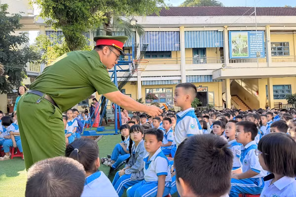 Học sinh nêu câu hỏi với các chiến sĩ Công an về cách sử dụng thiết bị kết nối Internet. (Ảnh: NT)