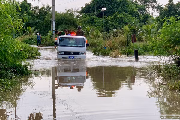 Lực lượng Công an xã Hàm Thạnh dùng xe chuyên dụng đưa học sinh, người dân qua điểm ngập lụt. (Ảnh: QT)