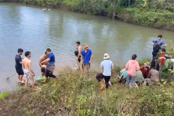 Người dân và cơ quan chức năng trục vớt 3 em nhỏ bị đuối nước.
