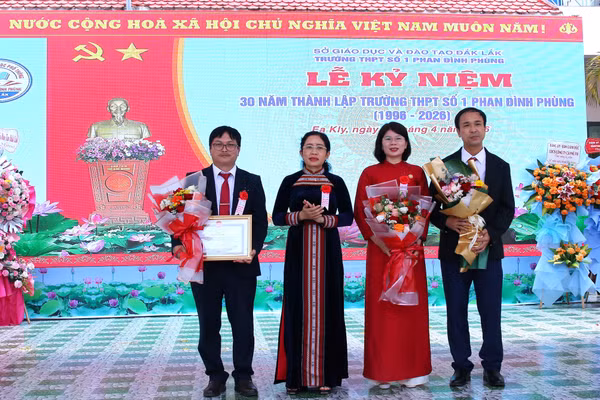 Giám đốc Sở GD&ĐT Lê Thị Thanh Xuân trao Bằng khen của UBND tỉnh Đắk Lắk cho tập thể nhà trường. (Ảnh: TT)