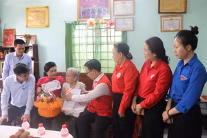 Ông Nguyễn Minh Nhựt, Chủ tịch Hội Chữ thập đỏ TPHCM trao quà đến các gia đình chính sách, người có công với cách mạng.
