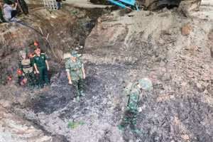 Cán bộ, chiến sĩ Đội tìm kiếm, quy tập hài cốt liệt sĩ dùng máy để dò tìm bom mìn có thể còn sót lại. 