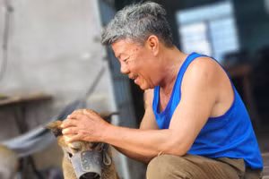 Ông Phan Văn Mạng cùng một trong 3 con chó mà gia đình nuôi. 