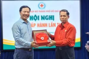 Ông Nguyễn Minh Nhựt (trái) nhận quà của Hội Chữ thập đỏ TPHCM.