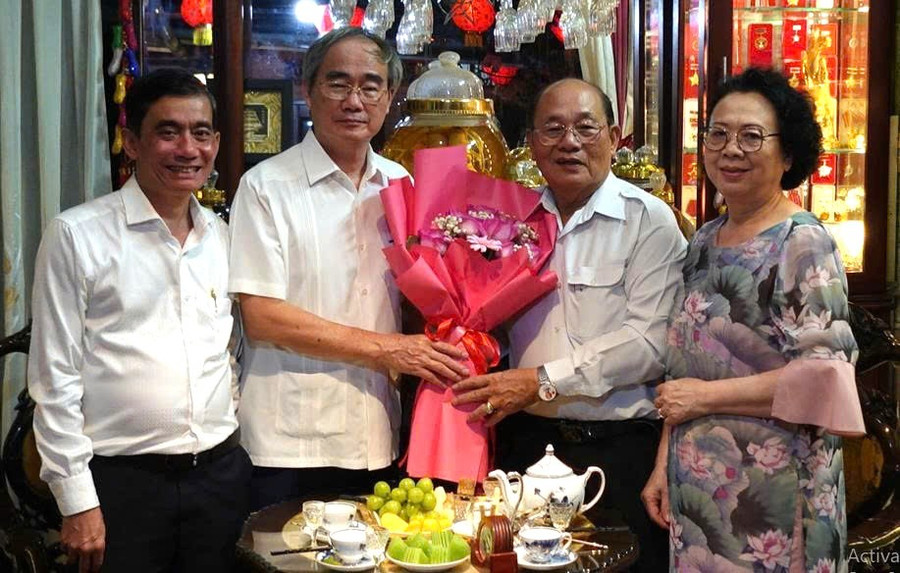 Nguyên Chủ tịch Ủy ban Trung ương MTTQVN Nguyễn Thiện Nhân tặng hoa chúc mừng NGND Thái Văn Long.