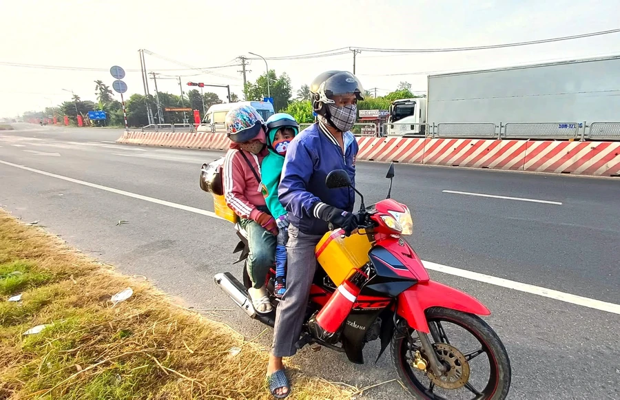 Người lao động miền Tây di chuyển trở lại nơi làm việc bằng xe gắn máy.