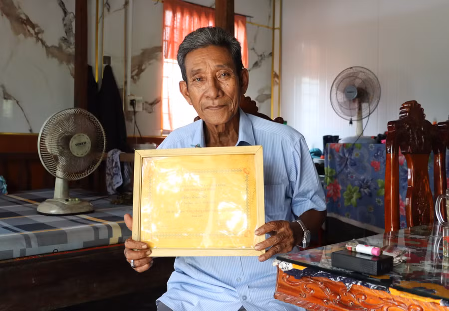 Ông Hữu Minh Út khoe tấm bằng chứng nhận gia đình hiếu học. Ảnh: Quách Mến.