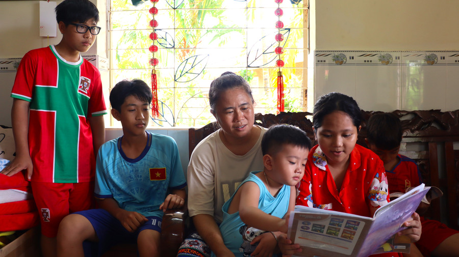 Bà Trương Thị Út quan sát các con học bài. Ảnh: Quách Mến