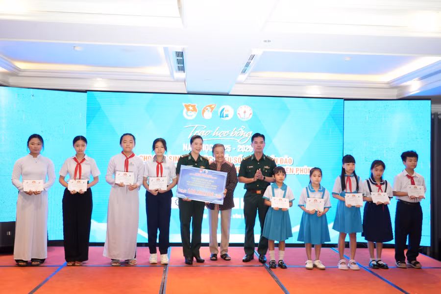 Bà Lê Minh Ngọc, Phó Chủ nhiệm CLB “Vì Hoàng Sa- Trường Sa thân yêu” trao học bổng cho đại diện Đồn Biên phòng và học sinh.