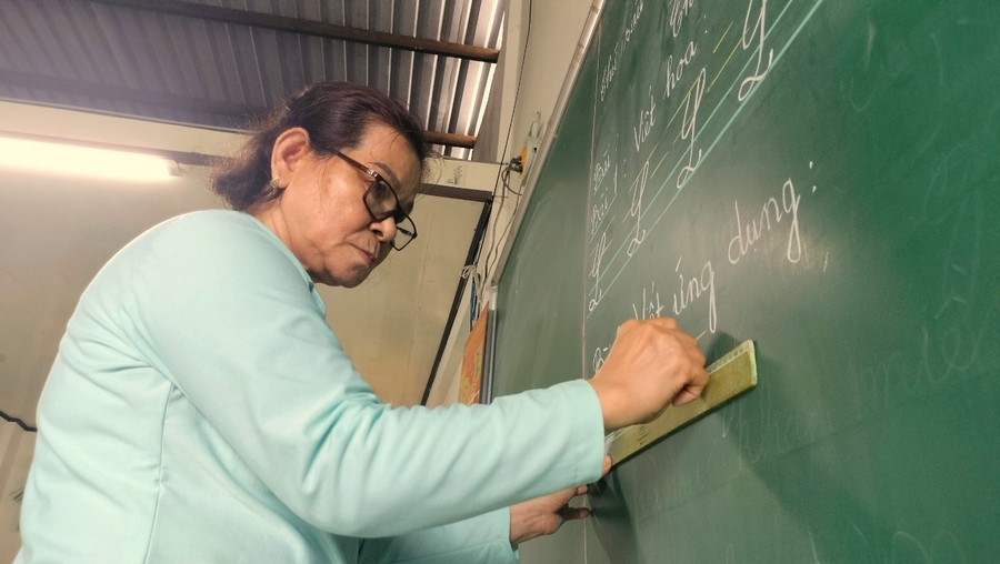 Cô Lê Thị Thu Thiết viết chữ lên bảng. nhung-giao-vien-khong-tuoi-huu-3.jpg