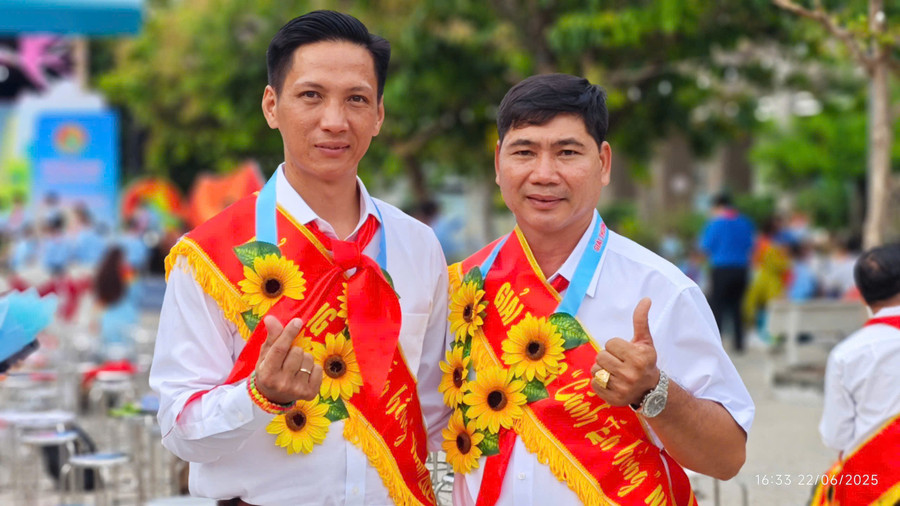 Thầy Trịnh Hoàng Thám (bên trái) chụp ảnh cùng đồng nghiệp khi nhận giải thưởng Cánh én hồng 2025.