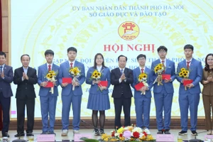 Phó Chủ tịch Thường trực HĐND thành phố Trần Thế Cương và lãnh đạo Sở Giáo dục và Đào tạo Hà Nội tặng hoa động viên các em học sinh.