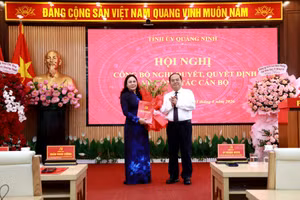 Ông Quản Minh Cường, Bí thư Tỉnh ủy Quảng Ninh trao quyết định, tặng hoa chúc mừng bà Nguyễn Thị Hiền, Bí thư Đảng ủy phường Móng Cái 1.