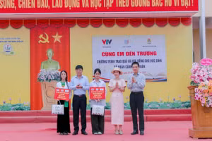 Chủ tịch Công đoàn Giáo dục Việt Nam Nguyễn Ngọc Ân cùng đại diện Quỹ Tấm lòng Việt trao học bổng cho học sinh.