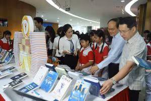 Các biểu và học sinh tham quan không gian trưng bày sách, báo tại Thư viện tỉnh Quảng Ninh. 