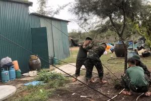 Cán bộ, chiến sĩ trên đảo Vĩnh Thực hỗ trợ người dân trên địa bàn gia cố nhà cửa.