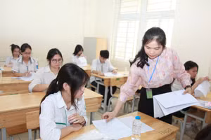 Giám thị phát giấy nháp thi cho các thí sinh.