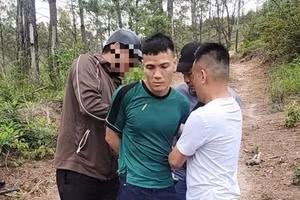 Nguyễn Văn Báo (mặc áo xanh) thời điểm bị bắt giữ.