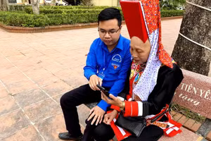 Đoàn viên hướng dẫn người dân cài đặt các ứng dụng chuyển đổi số ở Quảng Ninh.