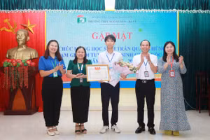 Lãnh đạo nhà trường trao thưởng cho học sinh Trần Quang Hùng.