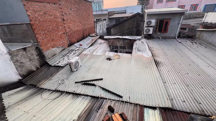 Lực lượng chức năng phải cắt mái tôn để đưa vòi xịt dập tắt ngọn lửa.