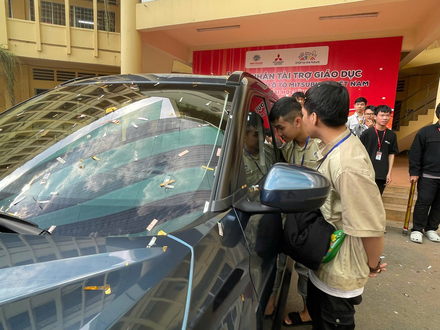Sinh viên Trường Đại học Bình Dương bên chiếc ô tô được tài trợ phục vụ thực hành. Ảnh: Hà An.