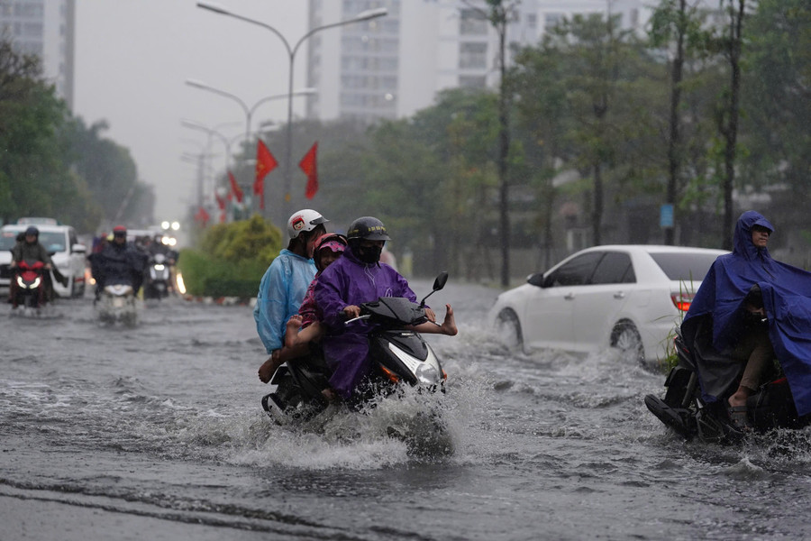 Mưa trái mùa xuất hiện trên diện rộng ở TPHCM khiến nhiều đường ngập nặng, người dân khó khăn đi lại, đúng giờ tan tầm.
