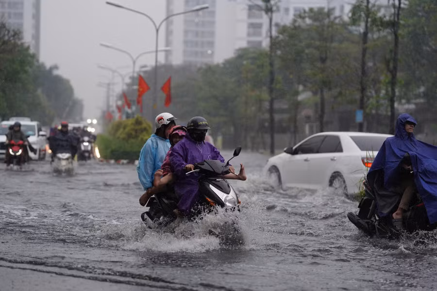 Mưa trái mùa xuất hiện trên diện rộng ở TPHCM khiến nhiều đường ngập nặng, người dân khó khăn đi lại, đúng giờ tan tầm.