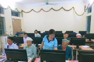 Cụ Phùng Mùi Coi (ngoài cùng bên phải), 68 tuổi, xóm Lũng Quáng, xã Huy Giáp (Cao Bằng) được cô giáo hướng dẫn học tập cùng máy tính.