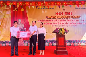 Ông Bế Đăng Khoa (bên trái), Tỉnh ủy viên, Giám đốc Sở Dân tộc và Tôn giáo tỉnh Cao Bằng tặng quà tại Hội thi Rung chuông vàng.