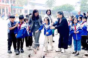 Em Kim Thanh Bình (lớp 3B, Trường Tiểu học Sơn Cẩm 1, phường Quan Triều, tỉnh Thái Nguyên) được hỗ trợ tập đi. 