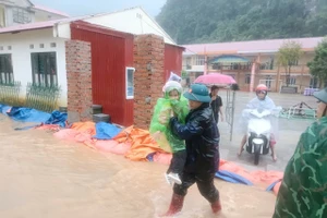 Lực lượng chức năng xã Xuân Trường (Cao Bằng) hỗ trợ di chuyển học sinh từ trường học bị ngập trong cơn bão số 10 đến nơi an toàn.