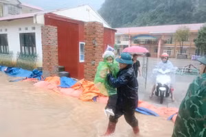 Lực lượng chức năng xã Xuân Trường (Cao Bằng) hỗ trợ di chuyển học sinh từ trường học bị ngập trong cơn bão số 10 đến nơi an toàn.