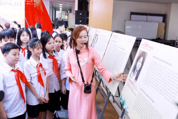 Học sinh cùng tham quan triển lãm ảnh "Sen trong đá" tại Trường THCS Ngô Sĩ Liên. Ảnh: Đình Tuệ.