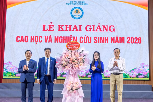 Lãnh đạo Học viện Tài chính nhận hoa chúc mừng từ các học viên cao học, nghiên cứu sinh năm 2026.