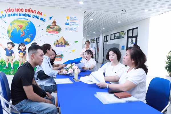 Phụ huynh đăng ký tuyển sinh trực tiếp cho con vào lớp 1 năm 2026 tại Hà Nội. Ảnh: Đình Tuệ.