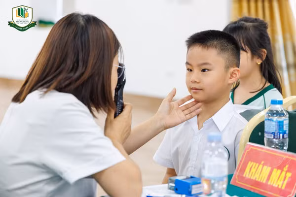 Nhân viên y tế khám mắt cho học sinh Trường Phổ thông Phùng Hưng.