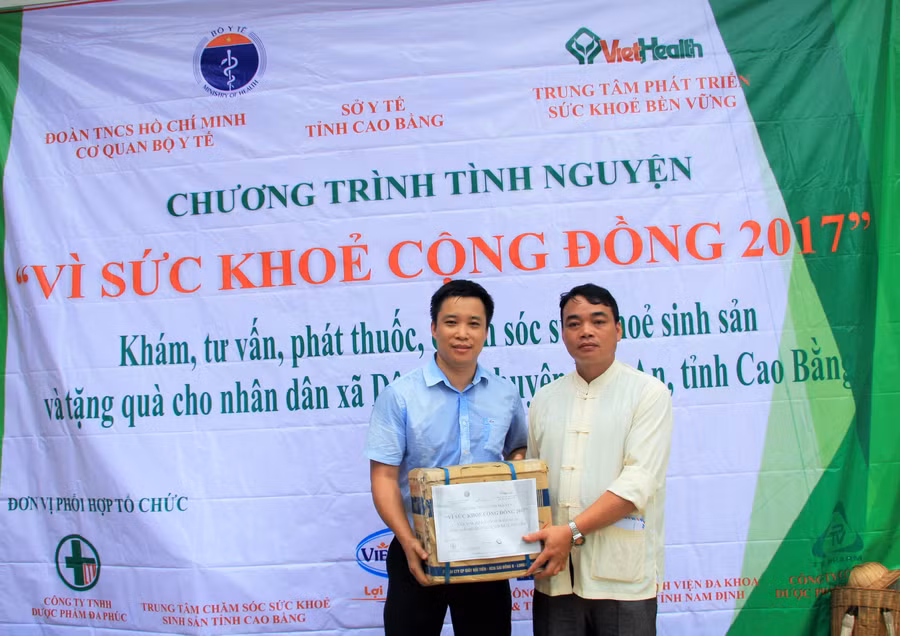 Ông Bùi Mạnh Hà (bên trái) – Giám đốc Công ty THHN dược phẩm Đa Phúc đại diện đoàn tình nguyện trao tặng quà cho đại diện lãnh đạo xã Dân Chủ.