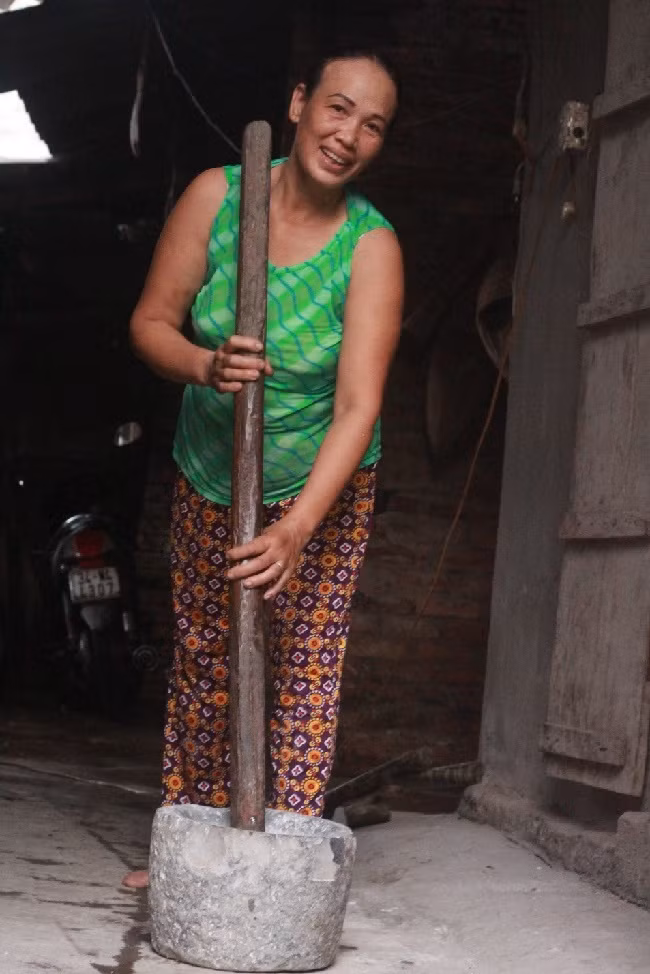 Gạo sau khi đã ngâm được đem đi giã thủ công và lọc nhiều lần. ảnh: Thu Hoài