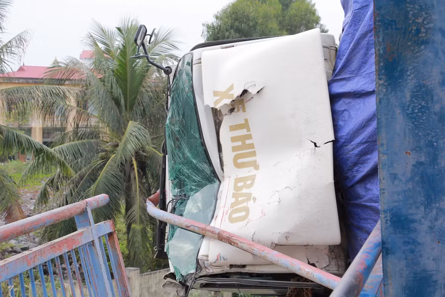 Xe ô tô lật ngang bên lái, phần đầu xe nằm chênh vênh ngoài thành cầu