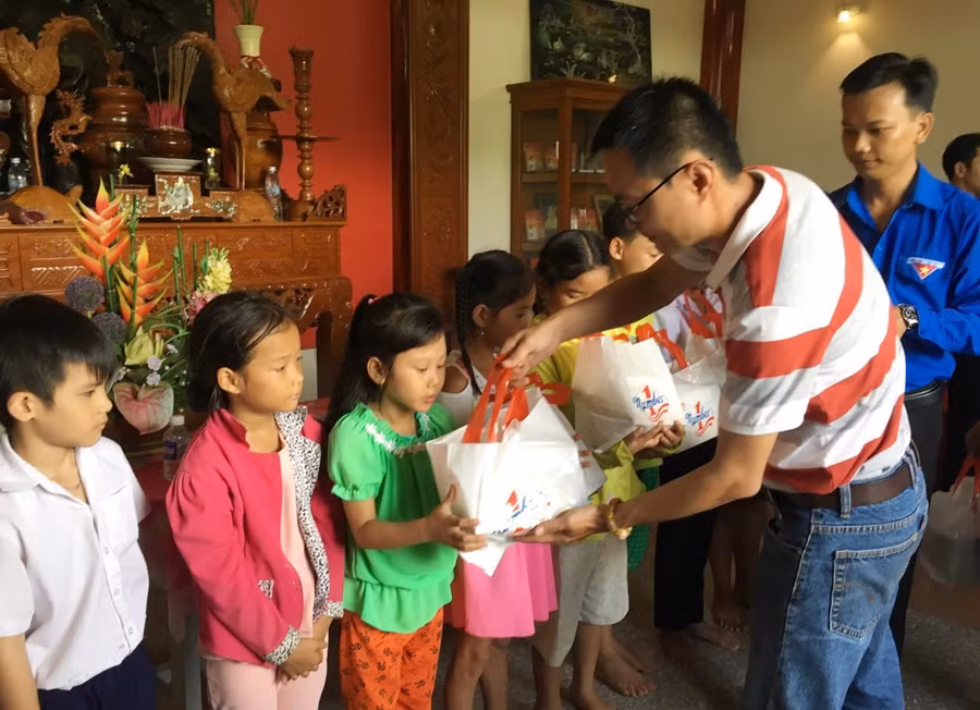Ông Lê Nguyễn Đức Khôi trao quà và học bổng cho các em học sinh ở xã Mỹ Phước Tây