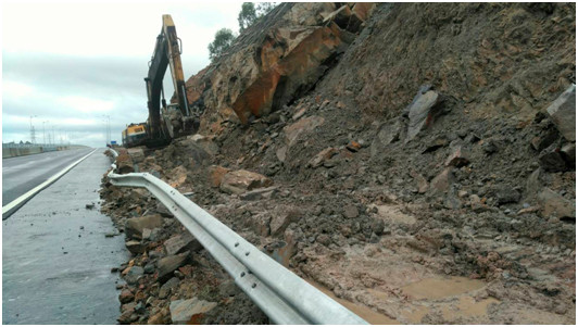 Phương tiện thiết bị của VEC xúc dọn đất đá bị sạt lở trên tuyến cao tốc Đà Nẵng-Quảng Ngãi.