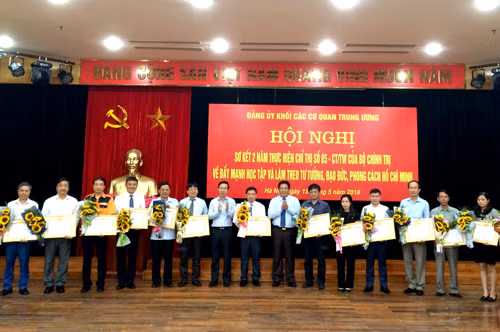 Trưởng Ban Tuyên giáo Trung ương Võ Văn Thưởng và lãnh đạo Đảng ủy Khối trao Bằng khen và tặng hoa chúc mừng các Đảng bộ cơ sở có thành tích xuất sắc trong học tập và làm theo tư tưởng, đạo đức, phong cách Hồ Chí Minh giai đoạn 2016-2018. Ảnh: VGP